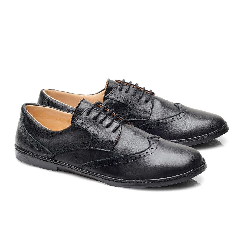 Seitenansicht eines Paars BRIQ Brogue Waterproof Black von ZAQQ, aus schwarzem Leder gefertigt und mit dekorativen Perforationen für einen zeitlosen Look.