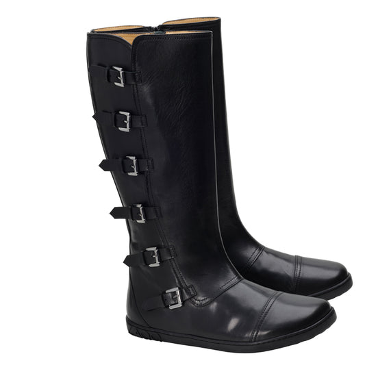 Ein Paar PAULIQ Black Boots von ZAQQ in hohem Design aus schwarzem Leder mit fünf verstellbaren Schnallenriemen an der Seite. Diese Stiefel zeichnen sich durch einen schlanken Stil und leicht abgerundete Zehenpartie aus, die bei jedem Schritt ein einzigartiges Barfußgefühl vermitteln.