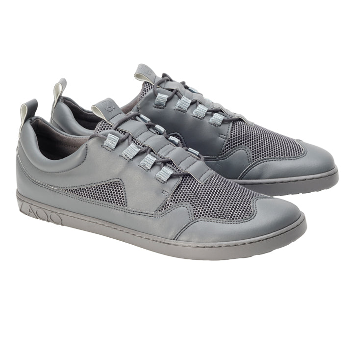 Wir präsentieren die stylischen QARLEE Grey Sneaker von ZAQQ mit einem raffinierten Design mit Mesh- und Lederakzenten. Diese Barfußschuhe verfügen über ein einzigartiges Spitzenmuster und eine strukturierte Gummisohle, die für ein modernes und sportliches Aussehen sorgen.