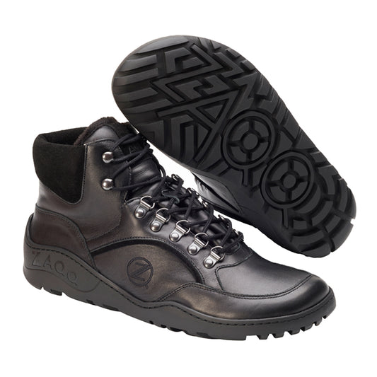 Die TREQ Black Winter Waterproof Wanderstiefel von ZAQQ eignen sich perfekt als Winterstiefel. Diese schwarzen Stiefel zeichnen sich durch ein markantes Profilmuster, metallische Ösen, schwarze Schnürsenkel und ein seitlich eingeprägtes Logo aus. Die Sohle weist ein auffälliges geometrisches Design auf.