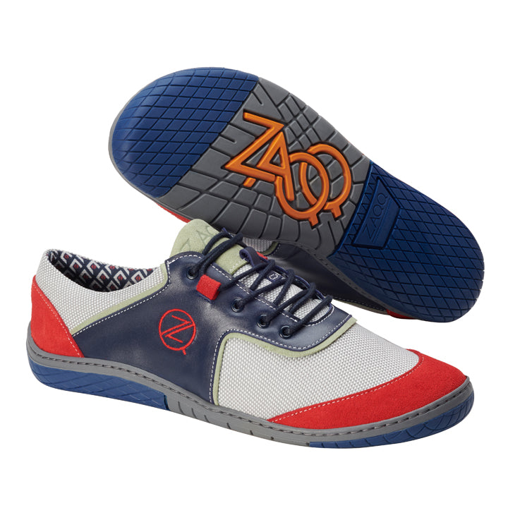 Die QOLE Blue Sneaker von ZAQQ fallen durch ihre leuchtend blaue Sohle und das orangefarbene Logo auf und bestehen aus einer Mischung aus roten, blauen und weißen Einsätzen aus Nappa- und Veloursleder. Diese stylischen Barfußschuhe sind mit hochatmungsaktivem Meshgewebe für Atmungsaktivität konzipiert und verfügen außerdem über graue Details, schwarze Schnürsenkel und ein Innenfutter mit geometrischem Muster.