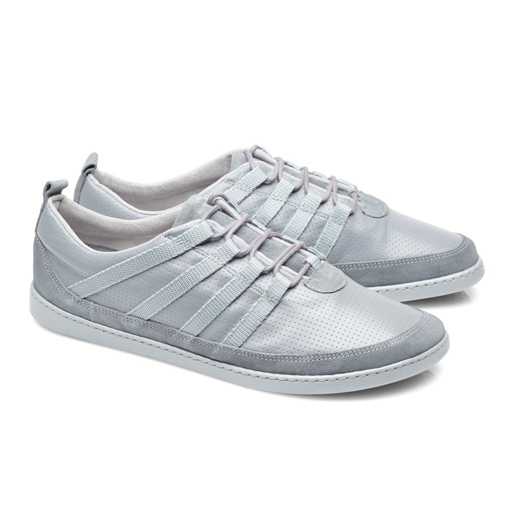 Wir präsentieren die SPARQ Low Grey Sneaker von ZAQQ: Diese hellgrauen Freizeit-Sneaker haben ein Obermaterial aus glattem Nappaleder mit perforierten Details. Sie verfügen über elastische Schnürsenkel und eine weiße Kautschuksohle und bieten ein schlankes und minimalistisches Design.