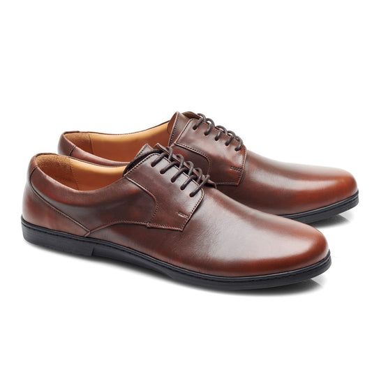 Ein Paar BRIQ Antique Brown-Abendschuhe von ZAQQ mit Schnürsenkeln, einem eleganten Design und schwarzen Sohlen vor einem weißen Hintergrund – perfekt als Ihr Businessschuh.