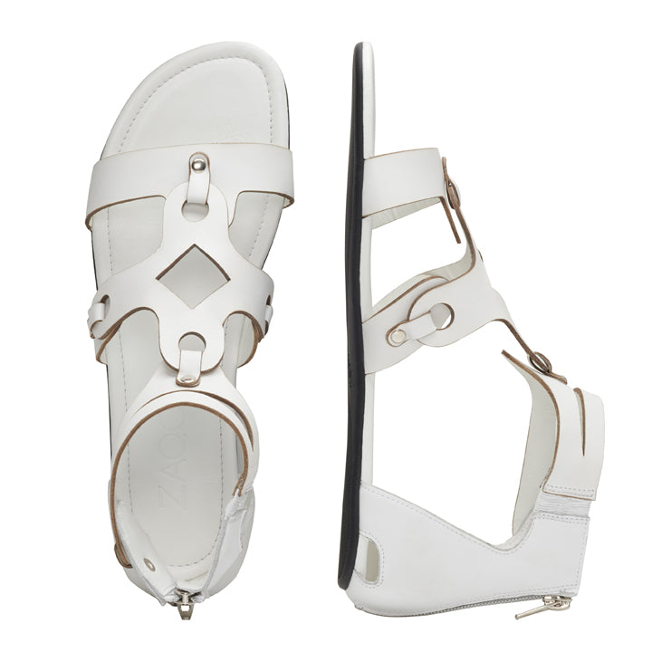 Die MAROQ White Sandalen von ZAQQ sind ein Paar schlichte, moderne Barfußsandalen aus Nappaleder. Sie verfügen über Knöchelriemen und geometrische Cut-Out-Designs mit Blick von oben und von der Seite, ergänzt durch kleine metallische Akzente und eine bequeme Kautschuksohle.