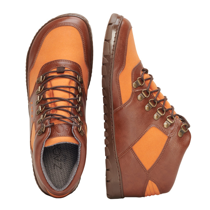 Die HIQE Mid Vegan Orange Waterproof-Stiefel von ZAQQ zeichnen sich durch ein robustes Sohlendesign in Braun und Orange aus, das von oben und von der Seite zu sehen ist. Diese veganen Wanderstiefel sind mit Metallösen und robusten Schnürsenkeln ausgestattet, was ihre wasserdichte Haltbarkeit und Eignung für Outdoor-Abenteuer unterstreicht – ideal für alle, die den abenteuerlichen Geist des ZAQQ HIQE-Stils suchen.