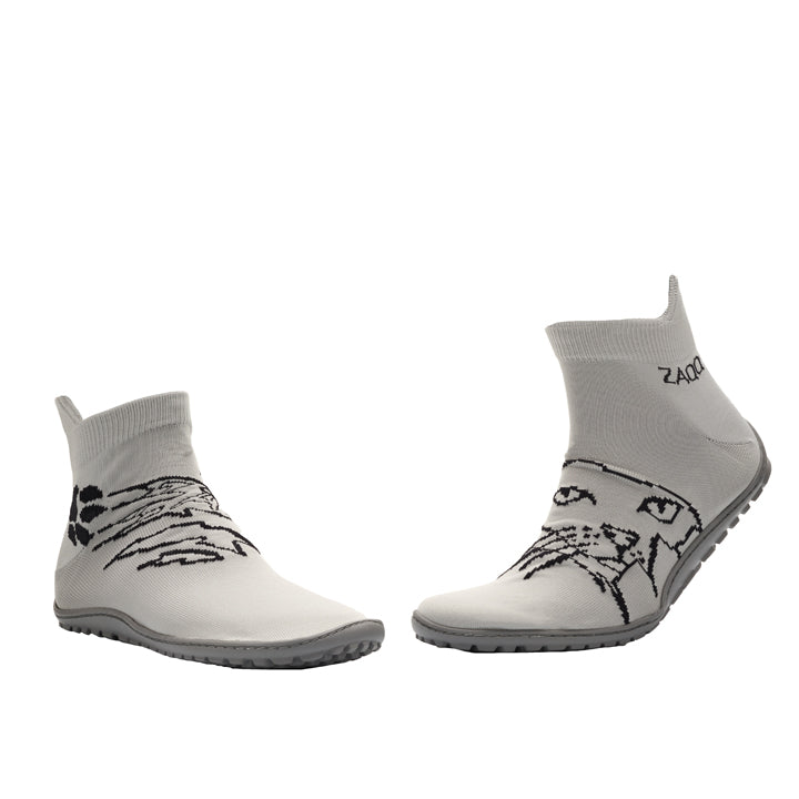 Zwei SOQQ Cat Grey Sockenschuhe von ZAQQ, in Weiß mit grauen Sohlen, zeigen auf der Vorderseite ein schwarzes Line-Art-Design eines Katzengesichts. Sie sind auf einem weißen Hintergrund angeordnet und stehen sich gegenüber.