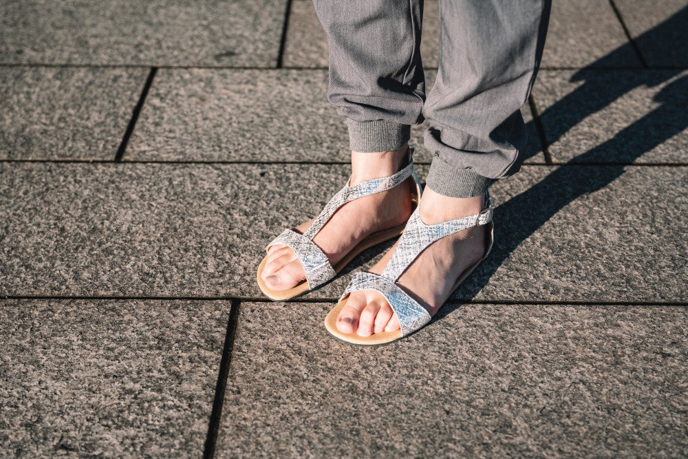 CLIQ Silver-Sandalen von ZAQQ mit silbernem Metallic-Finish, offenen Zehen, Knöchelriemen und einer Kautschuksohle auf weißem Hintergrund.