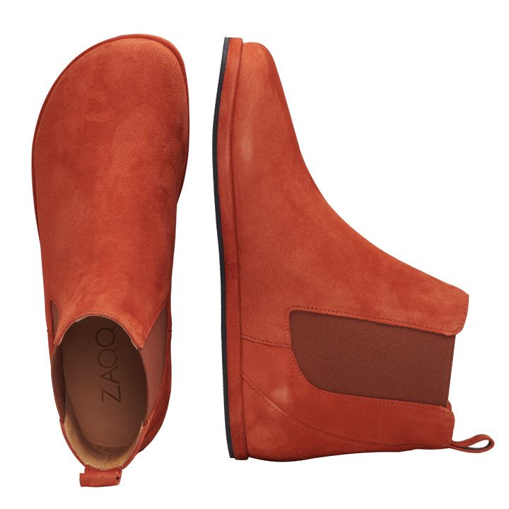 Zwei leuchtend rote Chelsea-Boots mit Knöchelhöhe, die EQUITY Terra von ZAQQ, werden hier gezeigt, einer von oben und der andere von der Seite. Diese Schuhe aus Veloursleder verfügen über elastische Seiteneinsätze und ein schlankes Design, das Tragekomfort für lässige Kleidung gewährleistet.