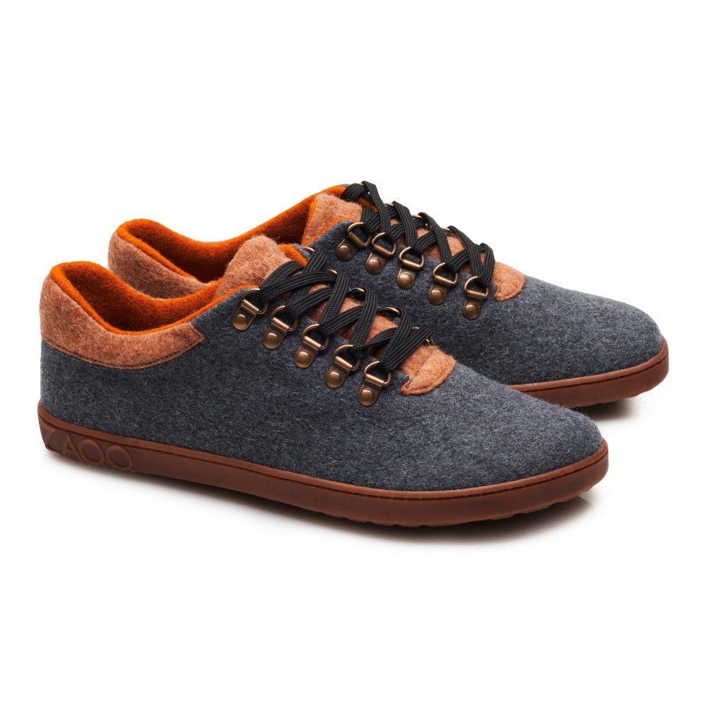 Wir präsentieren den eleganten LIQE Grey Toffee von ZAQQ, gefertigt aus Merinowolle. Dieser Low-Top-Barfußschuh besticht durch leuchtend orangefarbene Akzente, braune Sohlen und auffällige schwarze Schnürsenkel, alles vor einem schlichten weißen Hintergrund. Perfekt für alle, die bei jedem Schritt Wert auf Stil und Komfort legen.