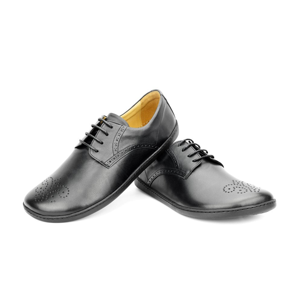 Wir präsentieren den ПЕАQ Brogue Black von ZAQQ, ein Paar elegante schwarze Business-Schuhe aus Leder mit aufwendigen Lochmustern an der Spitze und Schnürung vorne. Mit einem Schuh, der leicht nach vorne versetzt und erhöht ist, zeigen diese Schuhe ihr elegantes Design auf wunderschöne Weise.