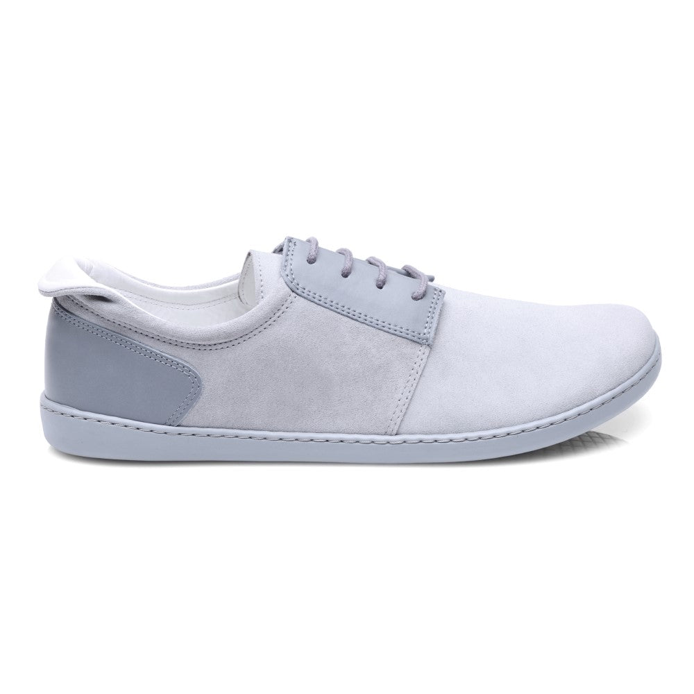 Der PIQUANT Lightgrey Sneaker von ZAQQ zeichnet sich durch ein minimalistisches Design mit einem hellgrauen Farbton, einer wildlederähnlichen Textur, grauen Schnürsenkeln und einer weiß-grauen Sohle aus. Er ist aus hochwertigem Veloursleder gefertigt und bietet ein gehobenes Finish, verfügt über eine Low-Top-Silhouette und eine Aufreißlasche an der Ferse.