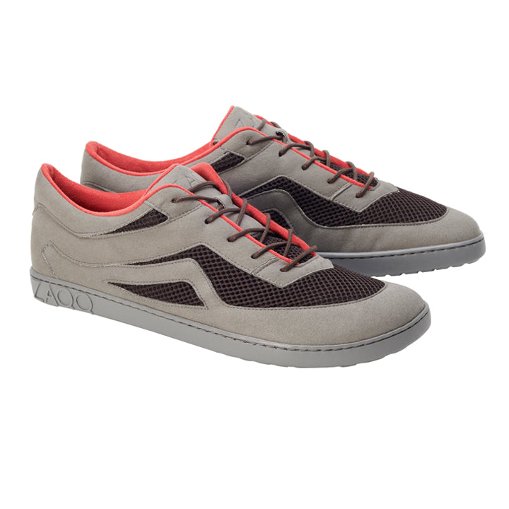 Wir präsentieren die ZAQQ QYNLEE Grey Sneaker, ein Paar stylische graue Schuhe aus hochwertigem Veloursleder. Mit schwarzen Mesh-Details und roten Akzenten, Schnürverschlüssen und einer strukturierten Sohle verbinden sie nahtlos moderne Eleganz mit sportlichem Flair.