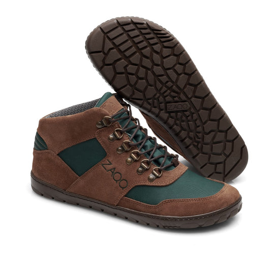 Ein Paar wasserdichte HIQE Mid Brown Green-Stiefel von ZAQQ mit dunkler Sohle. Ein Stiefel steht aufrecht und zeigt die Seiten- und Schnürdetails, während der andere umgedreht ist, um das Profil zu zeigen, ideal für Wanderfreunde auf der Suche nach zuverlässigem Abenteuerschuhwerk.