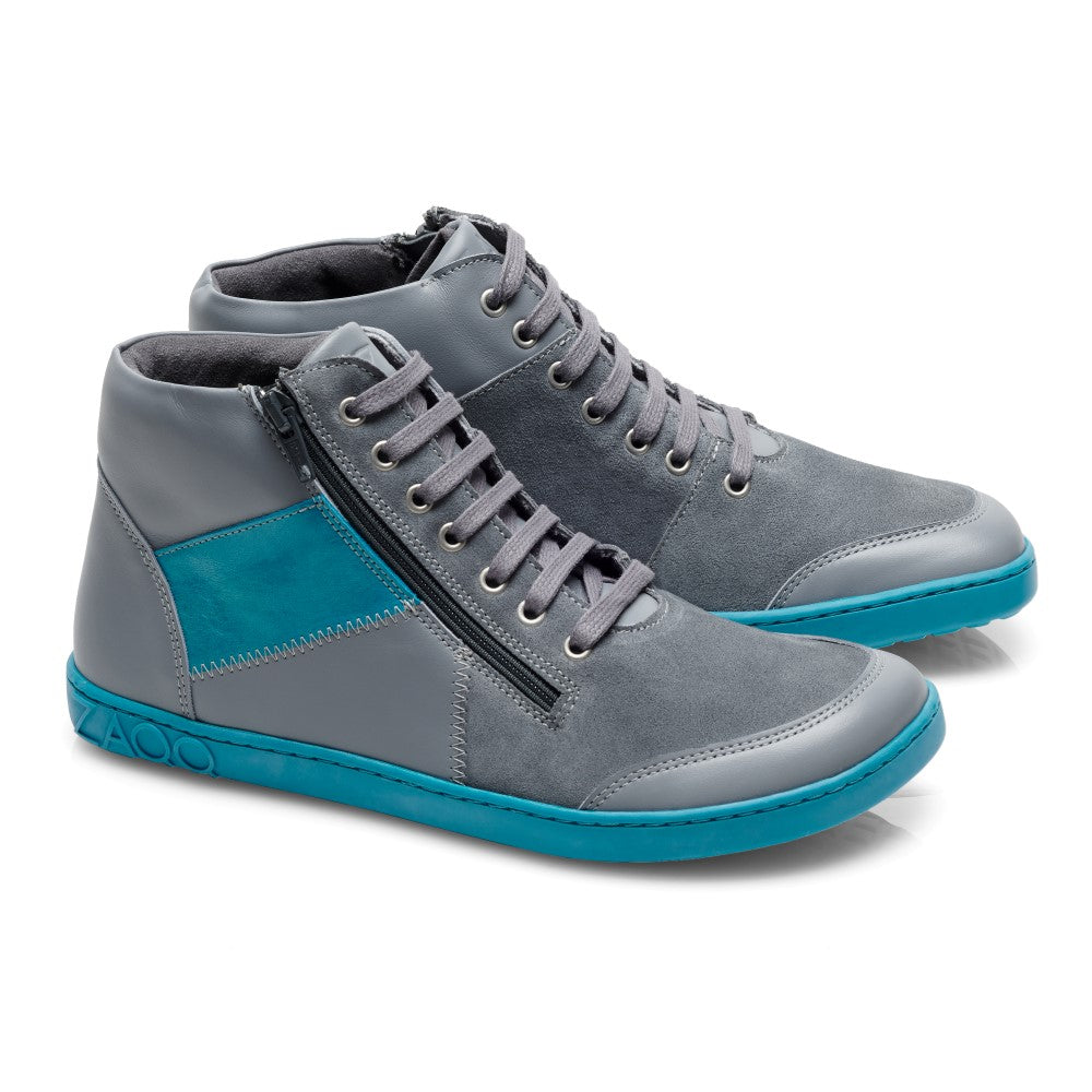 Wir präsentieren den LUQQ Turquoise von ZAQQ, ein stilvolles und modernes Paar grauer High-Top-Sneaker mit türkisfarbenen Akzenten und Sohlen. Diese mittelhohen Sneaker sind mit seitlichen Reißverschlüssen und Schnürung vorne ausgestattet und kombinieren glatte und strukturierte Materialien für einen eleganten Look, alles auf strapazierfähigen Kautschuksohlen.