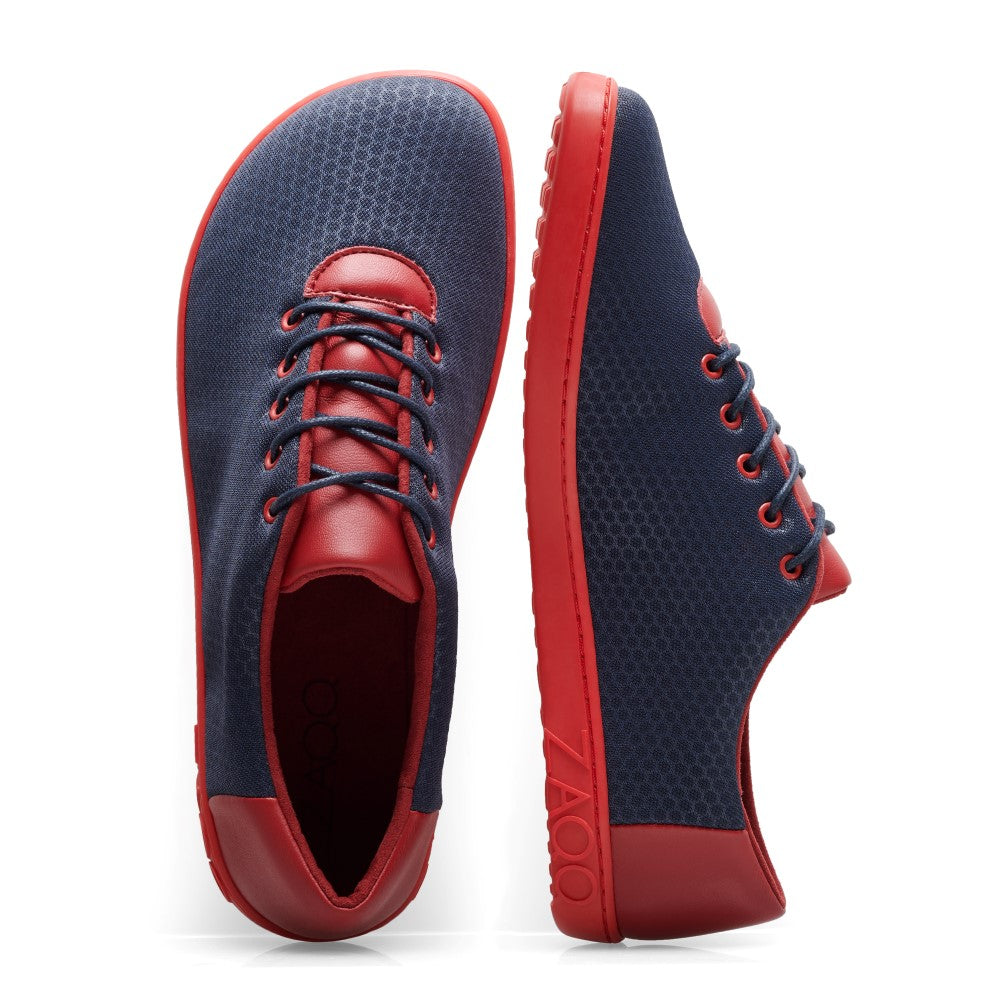 Wir präsentieren den QARO Navy Red von ZAQQ: ein Paar stylische Barfuß-Sneaker mit dunkelblauem Mesh-Obermaterial und auffälligen roten Akzenten an Zehen, Schnürsenkeln und Sohle. Diese Schuhe bieten ein modernes Design, das Komfort und Eleganz perfekt verbindet, hervorgehoben durch ihren deutlichen Farbkontrast und abgerundet durch eine strapazierfähige Kautschuksohle.